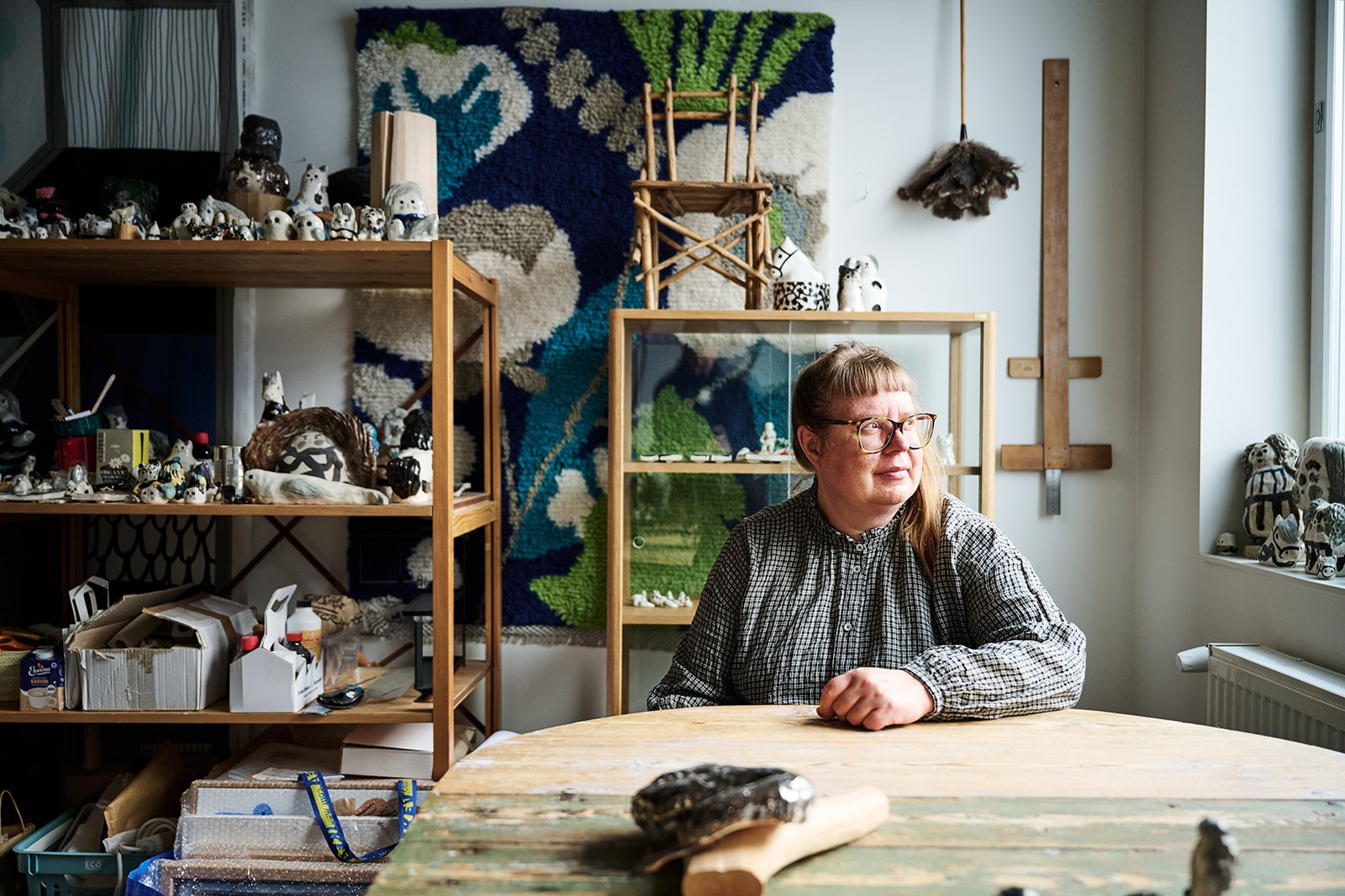 Jenni Tuominen studiossaan taidekeramiikkansa ympäröimänä